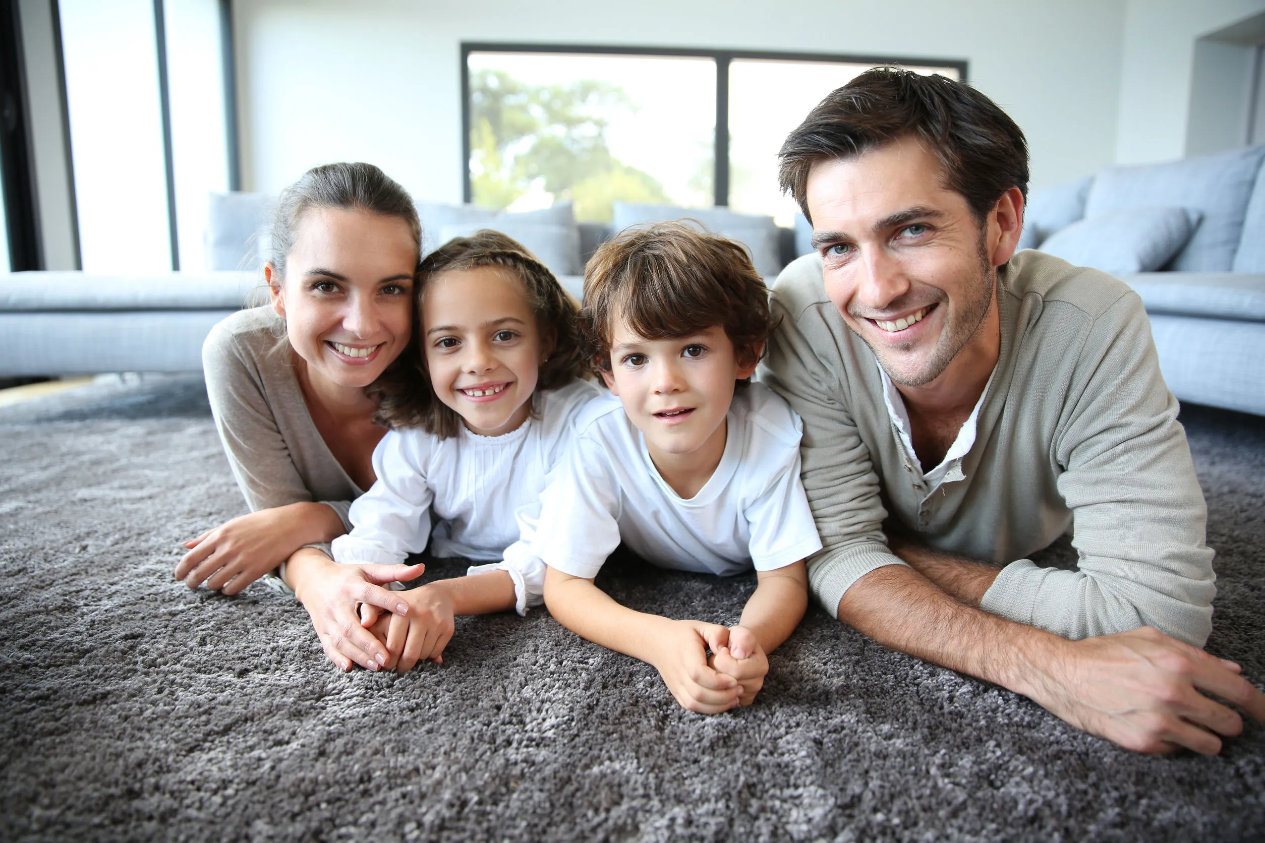 Familj som ligger tillsammans på en matta